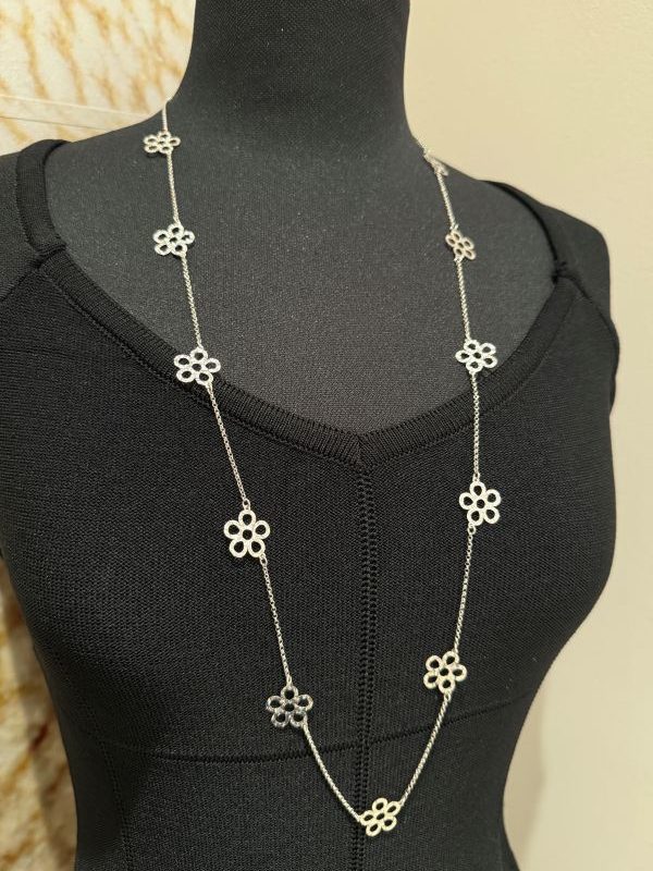 Un filo sottile d’argento che scorre con grazia, impreziosito da piccoli fiori battuti a mano, ognuno diverso, ognuno speciale. Questa collana lunga, realizzata artigianalmente in argento 925, nasce dalla pazienza e dall’estro dei nostri artigiani. Leggera e versatile, aggiunge un dettaglio raffinato a ogni outfit, portando con sé tutta la poesia del fatto a mano e il valore di un pezzo unico Made in Italy.