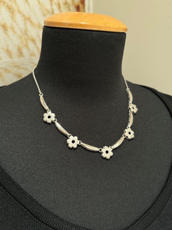 Un gioiello dal fascino etereo, delicato come un soffio di primavera. Questo girocollo, realizzato interamente a mano dai nostri artigiani, è un pezzo unico che incanta per la sua leggerezza visiva e la sua eleganza discreta. I fiori, lavorati uno ad uno con attenzione e passione, alternano superfici spazzolate e finiture lucide, creando un gioco sottile di contrasti e riflessi. Le diverse texture donano movimento e modernità, mantenendo però un’anima romantica e spensierata. Perfetto per chi cerca un tocco raffinato e originale, senza rinunciare alla grazia.