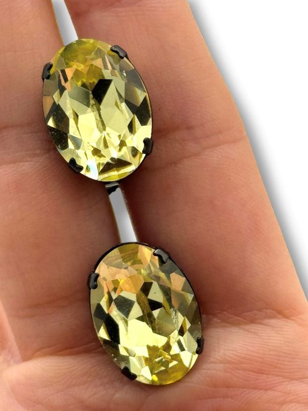Orecchino a clip con cristallo verde lime e montatura in metallo scuro. Design artigianale italiano, regolabile e comodo. Pezzo unico firmato Ave Caprice Parma. By Ave Caprice.
