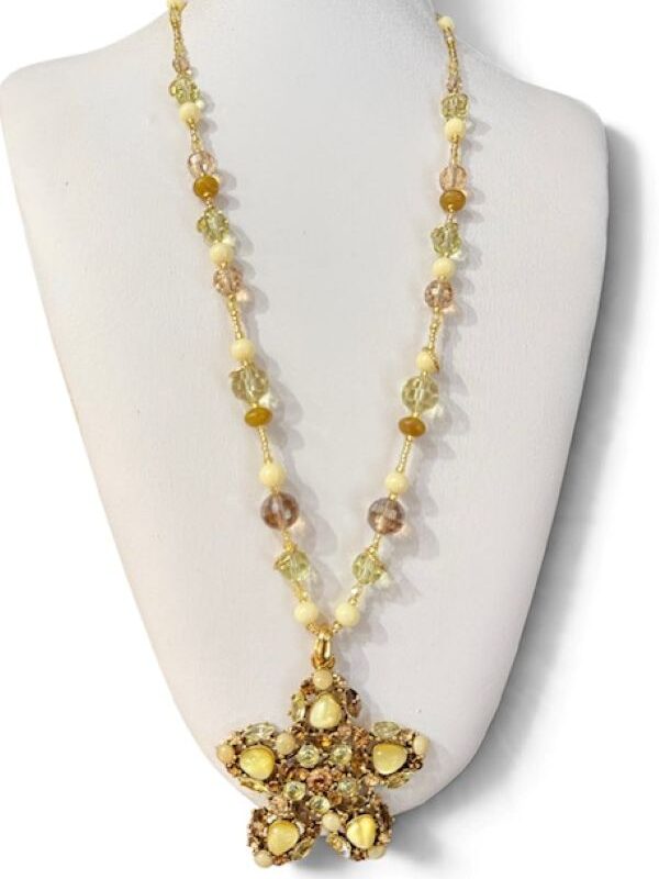Collana con grande ciondolo a stella con cristalli e cabochon nei toni del giallo e marrone montati su metallo dorato